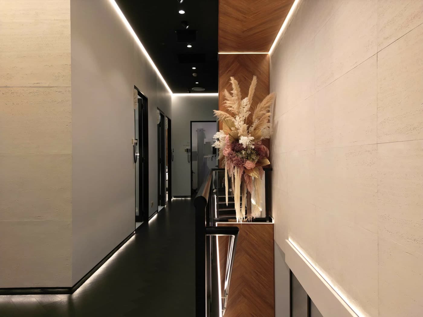 Softly lit corridor with a dried floral arrangement